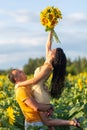 A beautiful young couple a man and a woman, embrace in a field of sunflowers at sunset Royalty Free Stock Photo