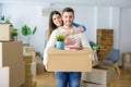 Beautiful young couple moving to a new house, smiling happy holding cardboard boxes at new apartment Royalty Free Stock Photo