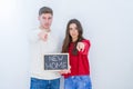 Beautiful young couple over white background holding blackboard with new home text pointing with finger to the camera and to you, Royalty Free Stock Photo