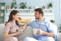 Beautiful young couple in pajamas is looking at each other and smiling on a sofa in the living room Royalty Free Stock Photo