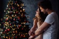 Beautiful young couple in pajamas on nicely decorated Christmas tree background. Royalty Free Stock Photo