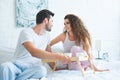 beautiful young couple in pajamas smiling each other while having breakfast together Royalty Free Stock Photo