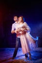 Beautiful young couple during a photo shoot in a dark Studio. A young man and a girl pose together on a black background Royalty Free Stock Photo