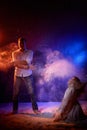 Beautiful young couple during a photo shoot with flour in a dark Studio. A young man and a girl pose together on a black Royalty Free Stock Photo