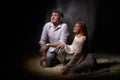 Beautiful young couple during a photo shoot with flour in a dark Studio. A young man and a girl pose together on a black Royalty Free Stock Photo
