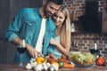 Beautiful young couple preparing a healthy meal together while spending free time at home. Royalty Free Stock Photo