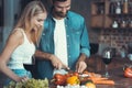 Beautiful young couple preparing a healthy meal together while spending free time at home.