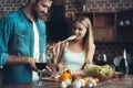 Beautiful young couple preparing a healthy meal together while spending free time at home.