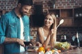 Beautiful young couple preparing a healthy meal together while spending free time at home.