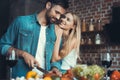 Beautiful young couple preparing a healthy meal together while spending free time at home.