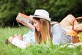 Beautiful young couple relaxing in city park, reading books while lying on a picnic blanket Royalty Free Stock Photo