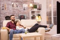 Beautiful young couple relaxing on sofa while watching a movie on tv Royalty Free Stock Photo