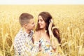 Beautiful young couple is resting on a wheat field. A girl in love and her boyfriend are hugging. Family outdoor recreation Royalty Free Stock Photo