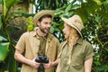 beautiful young couple in safari suits with binoculars hiking together