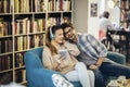 Young couple sitting in the cafe, drinking coffee and listening to music with smart phone Royalty Free Stock Photo