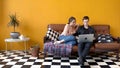 Beautiful young couple sitting together at laptop on couch. Stock footage. Couple of students together watching Royalty Free Stock Photo