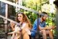 Young couple with smartphones sitting on stairs in town. Royalty Free Stock Photo