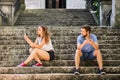 Young couple with smartphones sitting on stairs in town. Royalty Free Stock Photo