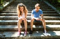 Young couple with smartphones sitting on stairs in town. Royalty Free Stock Photo