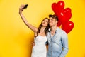 Cheerful couple taking selfie on smartphone while celebrating Valentine`s day