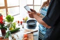 Beautiful young couple uses a digital tablet while cooking food in the kitchen at home Royalty Free Stock Photo