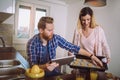 Young couple is using a digital tablet and smiling while cooking in kitchen at home Royalty Free Stock Photo