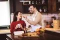 Young couple is using a digital tablet and smiling while cooking in kitchen at home Royalty Free Stock Photo