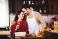 Young couple is using a digital tablet and smiling while cooking in kitchen at home Royalty Free Stock Photo