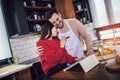 Young couple is using a digital tablet and smiling while cooking in kitchen at home Royalty Free Stock Photo