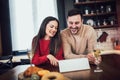 Young couple is using a digital tablet and smiling while cooking in kitchen at home Royalty Free Stock Photo