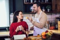 Young couple is using a digital tablet and smiling while cooking in kitchen at home Royalty Free Stock Photo