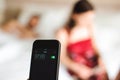 Beautiful young couple waking up with mobile alarm clock Royalty Free Stock Photo