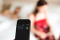 Beautiful young couple waking up with mobile alarm clock Royalty Free Stock Photo