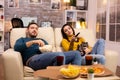 Beautiful young couple watching TV and eating fast food takeaway Royalty Free Stock Photo