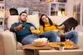 Beautiful young couple watching TV and eating fast food takeaway Royalty Free Stock Photo