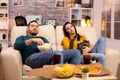 Beautiful young couple watching TV and eating fast food takeaway Royalty Free Stock Photo