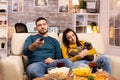 Beautiful young couple watching TV and eating fast food takeaway Royalty Free Stock Photo