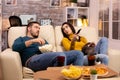 Beautiful young couple watching TV and eating fast food takeaway Royalty Free Stock Photo