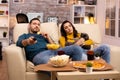 Beautiful young couple watching TV and eating fast food takeaway Royalty Free Stock Photo