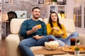 Beautiful young couple watching TV and eating fast food takeaway Royalty Free Stock Photo