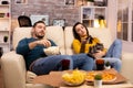 Beautiful young couple watching TV and eating fast food takeaway Royalty Free Stock Photo