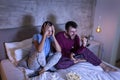 Couple playing video games in bed at night Royalty Free Stock Photo