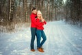 Beautiful young couple in winter in the woods, hug, happy romance