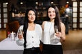 Beautiful young couple of women with glasses of champagne are celebrating in luxury restaurant Royalty Free Stock Photo