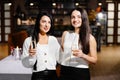 Beautiful young couple of women with glasses of champagne are celebrating in luxury restaurant Royalty Free Stock Photo