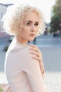 Beautiful young curly blond girl outdoors in the sun at sunset on a bright day Royalty Free Stock Photo