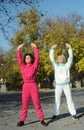 Beautiful young curly hair woman in pink sportswear and middle age 50s woman doing sports outdoors. Royalty Free Stock Photo