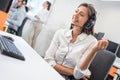 Beautiful young customer support female operator talking with client via hands-free headset in call center Royalty Free Stock Photo