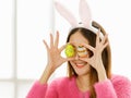 A beautiful young cute black long hair Asian woman covered her eyes with painted easter eggs Royalty Free Stock Photo