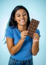 Attractive cute young woman with big bar of chocolate looking at it happy with temptation Royalty Free Stock Photo